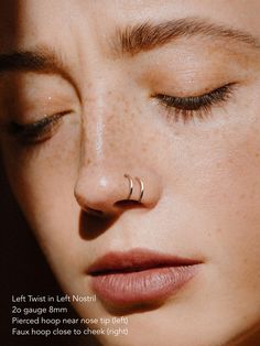 a close up of a woman's nose and nose piercing