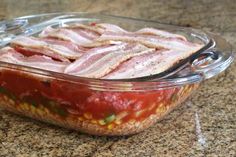 a glass casserole dish with meat in it on a granite countertop top