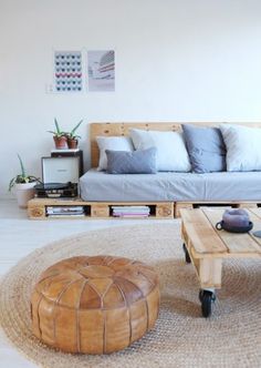 a living room with a couch, coffee table and ottoman on the floor in front of it