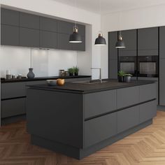 a modern kitchen with grey cabinets and black counter tops, an island in the middle