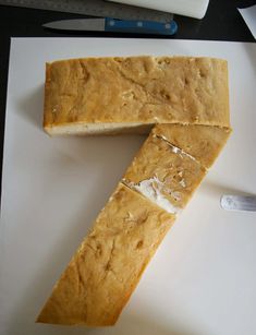 two pieces of bread sitting on top of a white cutting board next to a knife