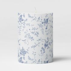 a blue and white floral candle on a white background