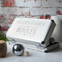 an open silver briefcase sitting on top of a table next to a potted plant