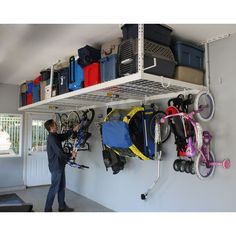 a man standing in front of a wall filled with lots of luggage and bike parts