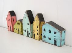 small wooden houses lined up against a white wall