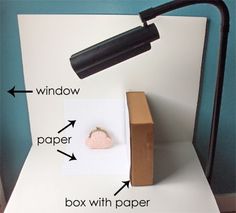 an image of a box with paper attached to it and a light on the side