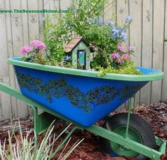 a wheelbarrow filled with flowers and plants