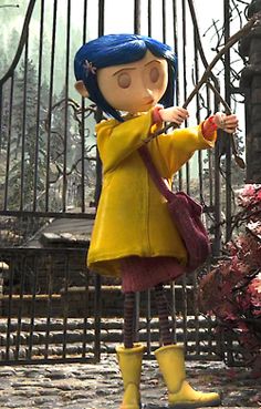 a doll is standing in front of a gate