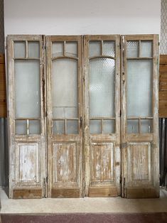 an old wooden double door with glass panels