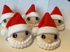 three crocheted santa hats with black eyes