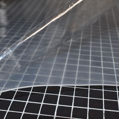 a piece of clear plastic sitting on top of a black and white tile flooring