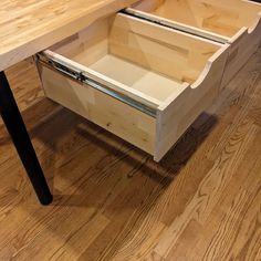 an open drawer on top of a wooden table