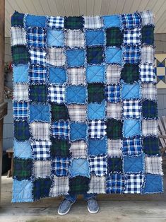 a person standing in front of a blue and white quilt on a porch with their feet propped up