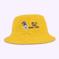 "Fool Time Employee" bucket hat - a quirky and playful nod to clowncore and kidcore aesthetics. Featuring a vibrant clown graphic, this hat is perfect for anyone embracing their inner fool or adding a splash of fun to their wardrobe. Made for those who love bold, colorful, and nostalgic styles, this bucket hat is both a fashion statement and a reminder not to take life too seriously. Whether you're rocking it at a festival or just hanging out, this hat will keep the laughs coming! .: Material: 100% polyester .: Available in 2 sizes .: Sewn-in label .: Made in USA Fun Affordable Multicolor Hat, Kidcore Clown, Clown Aesthetic, Kandi Kid, Y2k Accessories, Funny Gift Idea, Kid Core, Sew-in Labels, The Fool