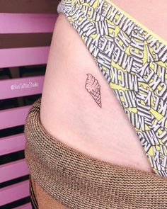 a small tattoo on the side of a woman's lower back ribcage