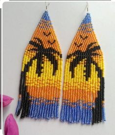 the beaded earrings are designed to look like a bird with blue eyes and yellow feathers