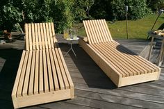 two wooden lounge chairs sitting on top of a wooden deck