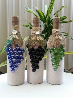 three wine bottles decorated with beads and plants