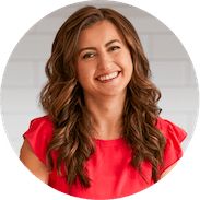 a woman with long brown hair and red shirt smiling at the camera in front of a white background