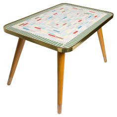 a small table with wooden legs and a mosaic design on it