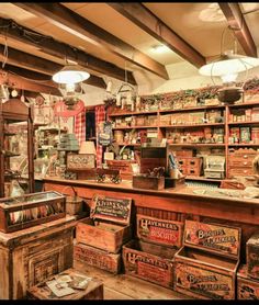 an old fashioned store with lots of wooden boxes on the floor and shelves full of items