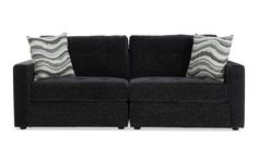 two black couches with pillows on them against a white background and one has a pillow