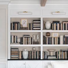 a bookshelf filled with lots of books and vases