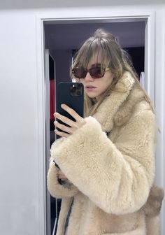 a woman taking a selfie with her cell phone in front of a closet door