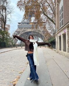 a woman is posing in front of the eiffel tower