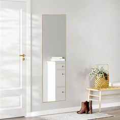 a room with a white door and a mirror on the wall next to a wooden bench