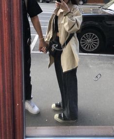 a woman standing in front of a mirror taking a selfie with her cell phone