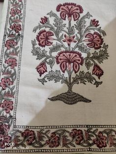 an embroidered table cloth with flowers on it