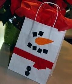 a snowman bag sitting on top of a table with red flowers in the background