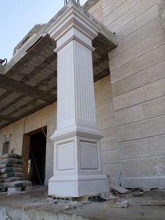 a tall white clock tower sitting in the middle of a building under construction on top of a pile of rubble