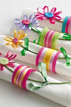 four napkins decorated with ribbons and flowers on top of each other in different colors