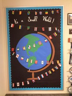 a bulletin board that says it's a small world with flags hanging on the wall