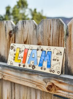 a wooden sign with the word farm painted on it's side next to a fence