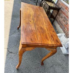 a wooden table sitting on top of a sidewalk