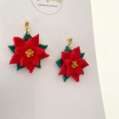 two red and green poinsettia earrings are on display