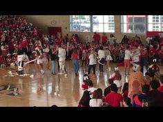 a group of people standing on top of a gym floor next to each other in front of a crowd