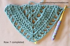 a crocheted triangle with a knitting needle next to it