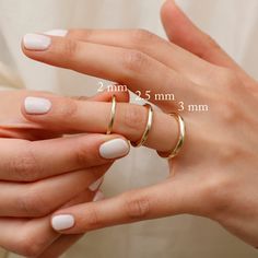 a woman's hands with two rings on her fingers and the measurements for each ring