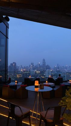 an outdoor dining area overlooking the city at night