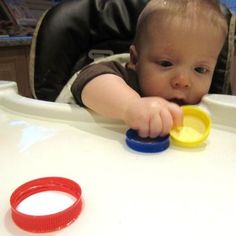 a baby in a high chair playing with a toy