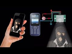 a hand holding a cell phone and an image of a person in a black mask