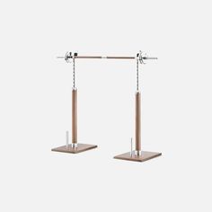 a pair of metal and wood stands with two poles on each side, one holding an object