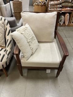 two chairs with pillows on them in a store