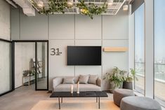 a living room with two couches and a flat screen tv mounted to the wall