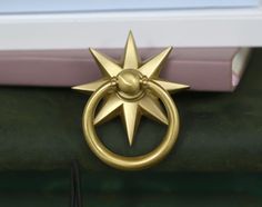 a gold ring with a star on it is sitting next to a book and some books