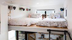 a bed sitting on top of a wooden shelf next to a window in a room